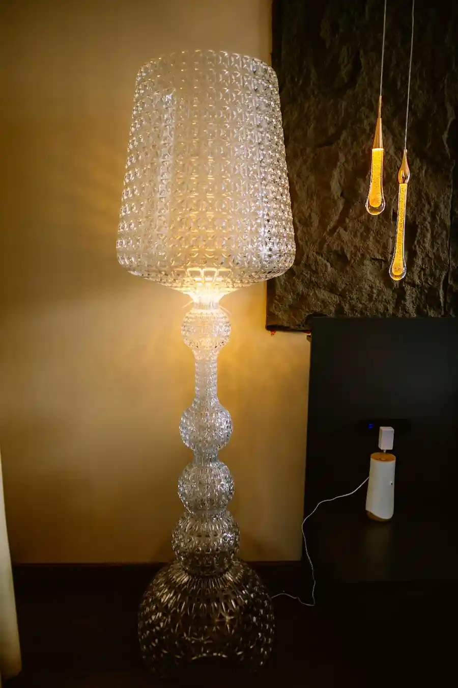 Elegant clear textured floor lamp glowing warmly inside the Bedroom Deluxe Two Queen Beds at Turtle Seaweed Resort.